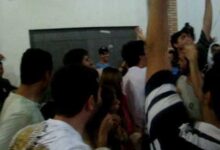 Estudantes em um churrasco universitário entoando um hino polêmico, típico de festas universitárias