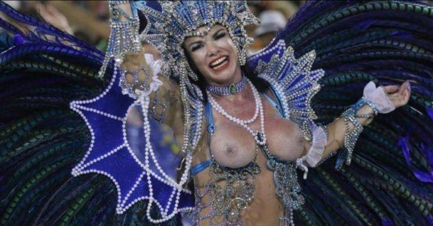 Musa de escola de samba com fantasia minúscula, peitos quase escapando da purpurina